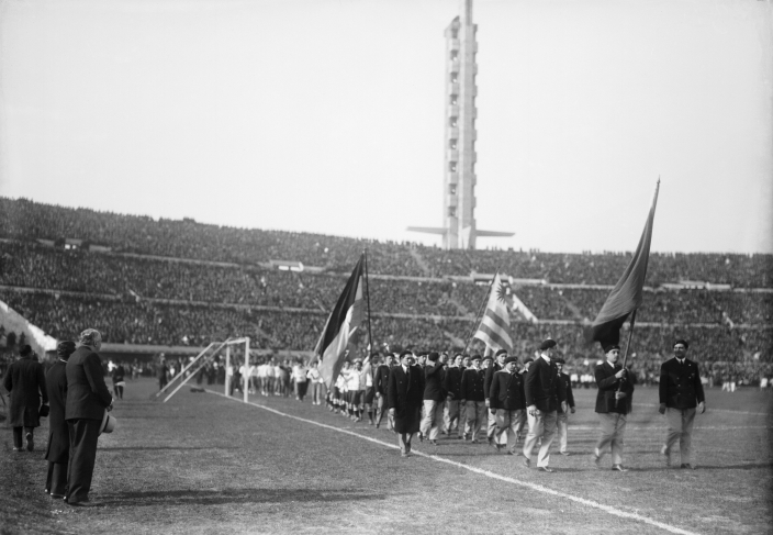 Inaugural ceremony of the Centenario Stadium. Delegations parade. At the rear end, the “Olímpica” stand and the “Homage Tower.” July 18th, 1930.