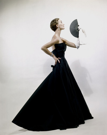 Erwin Blumenfeld.
Black satin evening dress, one long white glove holding fan, Dior. 
1949. 
© Conde Nast US