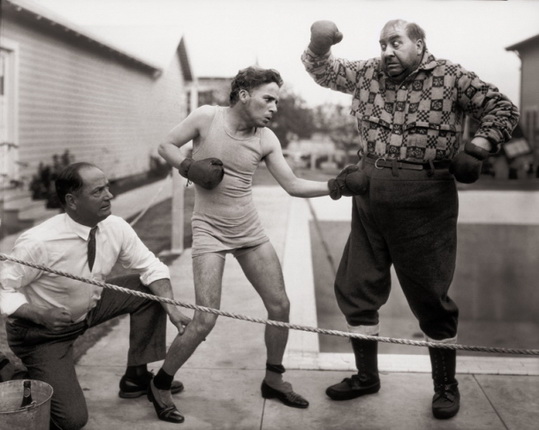 Boxing with actor Mack Swain in his Gold Rush costume. The referee is the real boxer Kid McCoy. (1923-1925).
© Roy Export Company Establishment, courtesy NBC Photographie, Paris
