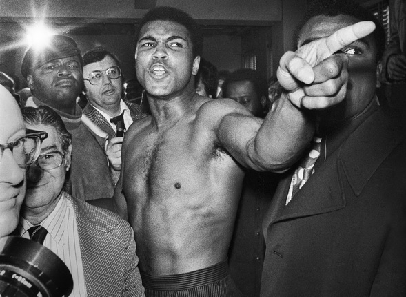 Jean-Pierre Laffont.
Ali vs. Frazier Ali pointing his finger.
Manhattan, New York City, NY - January 23, 1974.
Surrounded by press and bodyguards, Muhammad Ali gestures before brawling with Joe Frazier at the New York studio of ABC during the weigh-in process.
© Jean-Pierre Laffont / from the book “Photographer's Paradise. Turbulent America 1960-1990” (Glitterati)