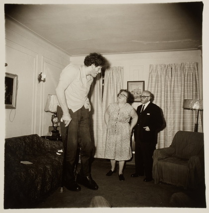Диана Арбус.
Это Эдди Кармел, еврей-гигант с родителями в гостиной их дома в Бронксе.
США, 1970.
Серебряно-желатиновый отпечаток.
Предоставлено фотомузеем WestLicht, Вена
