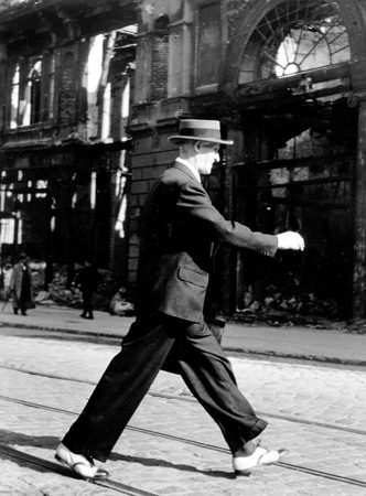 Pierre Boulat.
Berlin right after the war: a man walking in the street with brand new shoes bought in the United States in 1939. 
1945. 
© Pierre Boulat / COSMOS