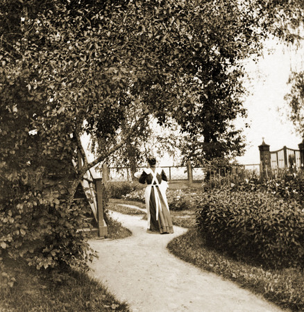 Nurse Tatiana Titovna with baby in her hands (K. V. Pigarev) in front of outhouse balcony
