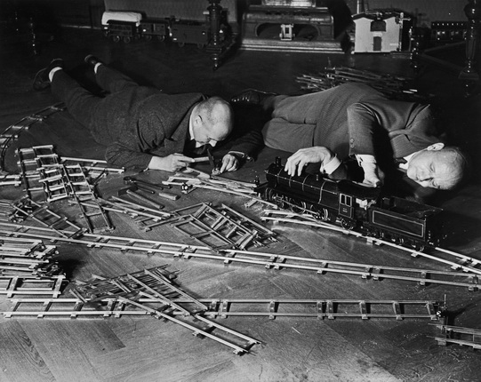 Alfred Eisenstaedt.
Two elderly men lie on the floor at the Toy Train Society. One uses a small hammer on a switchplate and the other makes adjustments to an engine car.
Berlin, Germany, 1931.
© Alfred Eisenstaedt // Time Life Pictures / Getty Images