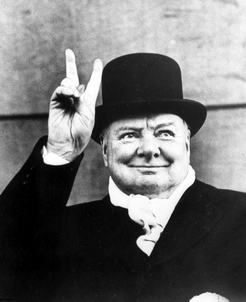 Alfred Eisenstaedt.
British PM Winston Churchill sporting top hat with coat and scarf as he holds up veed fingers.
1951.
© Alfred Eisenstaedt // Time Life Pictures / Getty Images